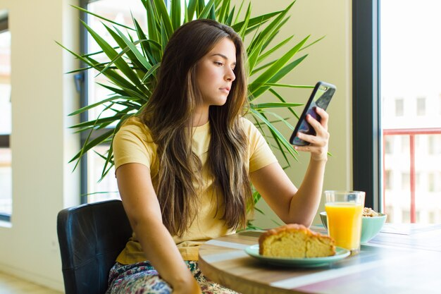 girl sitting with phone in cafe